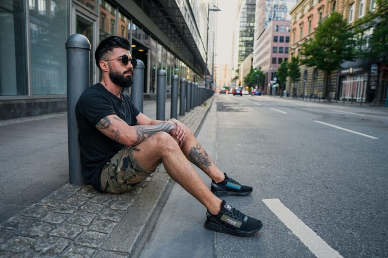Streetwear model showing how to style shorts in 2026 with a hoodie and snapback